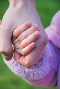 Close-up of clasped hands outdoors