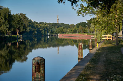 Wooden posts in lake against sky