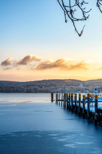 Pier on sea against sky during sunset