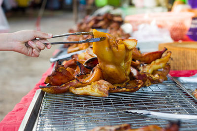 Close-up of person preparing food on barbecue grill