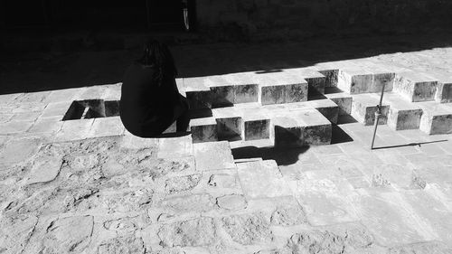 High angle view of woman sitting on staircase