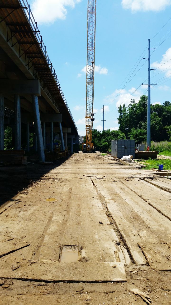 built structure, architecture, building exterior, sky, the way forward, electricity pylon, power line, street, diminishing perspective, sunlight, fuel and power generation, outdoors, empty, day, no people, low angle view, shadow, electricity, vanishing point, walkway