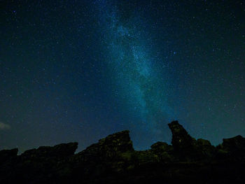 Low angle view of silhouette mountain against star field