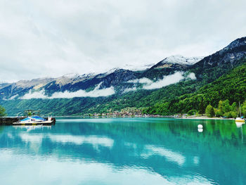 Scenic view of lake by mountains against sky