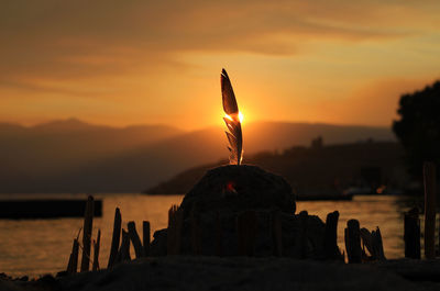 Sand castle at shore of lake chelan against sky during sunset