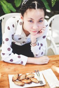 Portrait of cute girl sitting on table