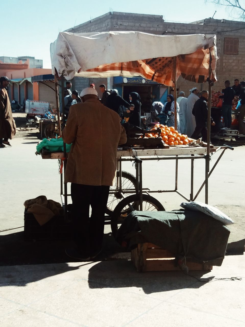 REAR VIEW OF PEOPLE WORKING AT MARKET STALL