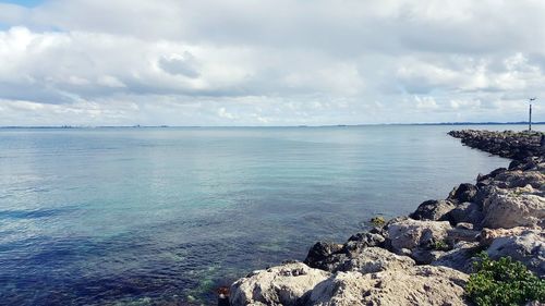 Scenic view of sea against cloudy sky