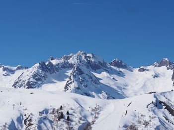 Scenic view of snowcapped mountains against clear blue sky