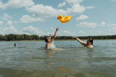 Rear view of woman jumping in sea