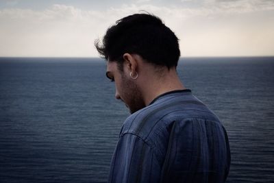 Portrait of young man by sea against sky