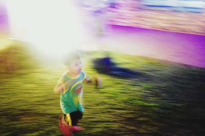 Full length of young woman running on grass