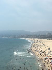 People at beach against sky