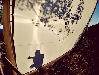 Rear view of silhouette man in boat against sky