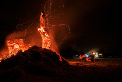 Fire on field against sky at night