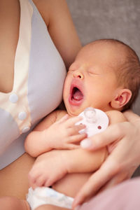 Midsection of mother with yawning baby