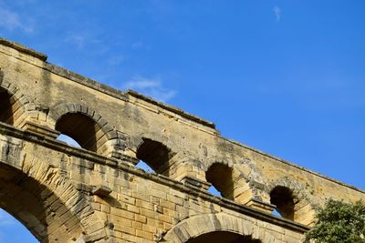 Low angle view of old building against blue sky