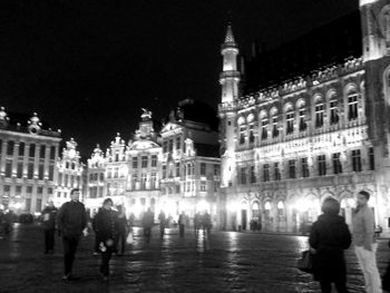 People on illuminated building at night