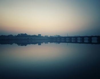 Scenic view of lake against clear sky during sunset