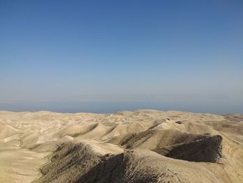 Scenic view of desert against clear blue sky