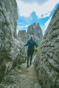 Rear view of woman walking amidst rock formations