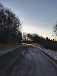 Road amidst trees against sky