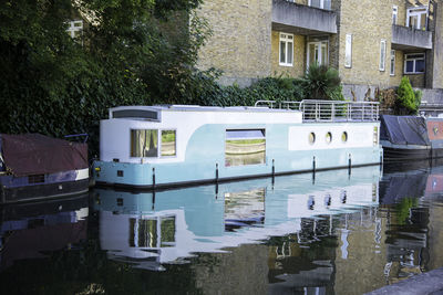 Boats moored on canal against building