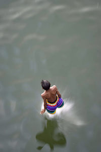 Rear view of man swimming in lake