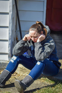 Full length of woman sitting outdoors