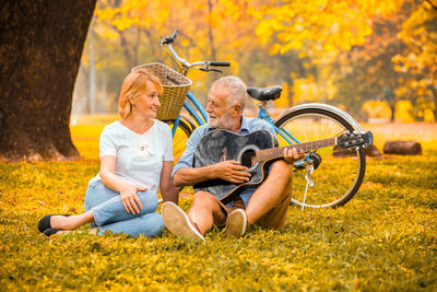 Men sitting on field during autumn