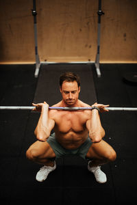 Shirtless man exercising in gym