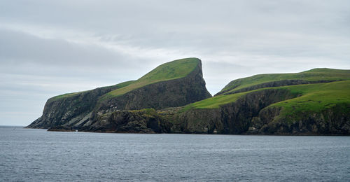 Scenic view of sea and mountains against sky