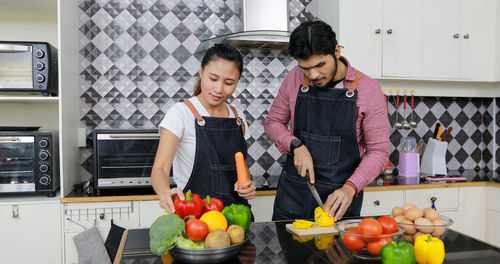 Friends standing by fruits at home