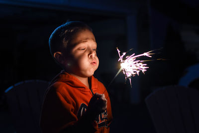 Close-up of boy blowing sparkler