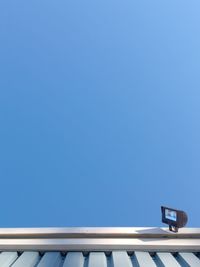 Low angle view of sign against clear blue sky