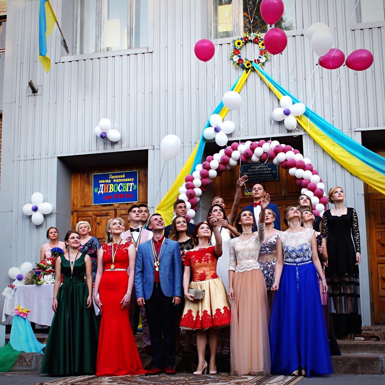 architecture, building exterior, balloon, multi colored, built structure, smiling, statue, outdoors, boys, clown, large group of people, men, day, city, people