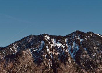 Scenic view of snowcapped mountains against clear blue sky