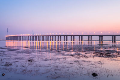 Pier over sea against sky during sunset