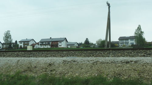 Railroad tracks by trees against sky