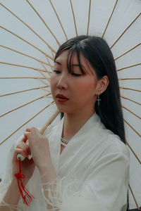 Portrait of smiling young woman holding umbrella