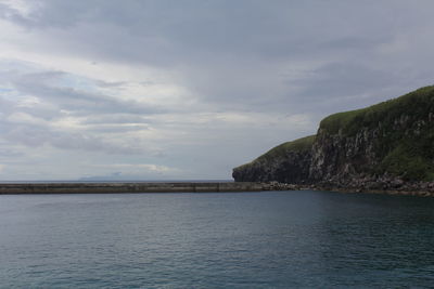 Scenic view of sea and mountains against sky