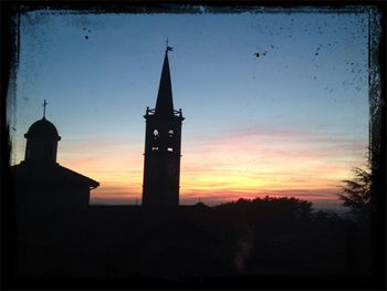 Low angle view of tower against sky at sunset