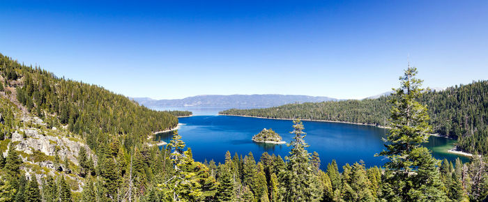 Scenic view of lake and mountains against clear blue sky