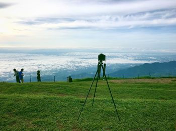 Man photographing on field against sky