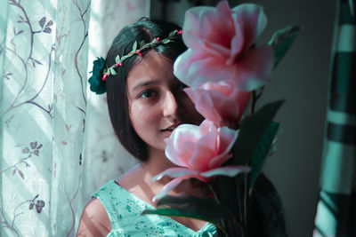 Close-up portrait of woman with pink flower