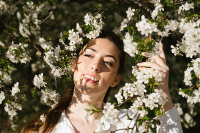 Portrait of young woman with flowering plants