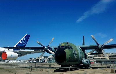 Airplane on airport runway against blue sky