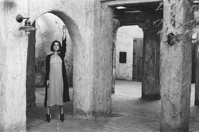 Rear view of woman standing in front of historic building