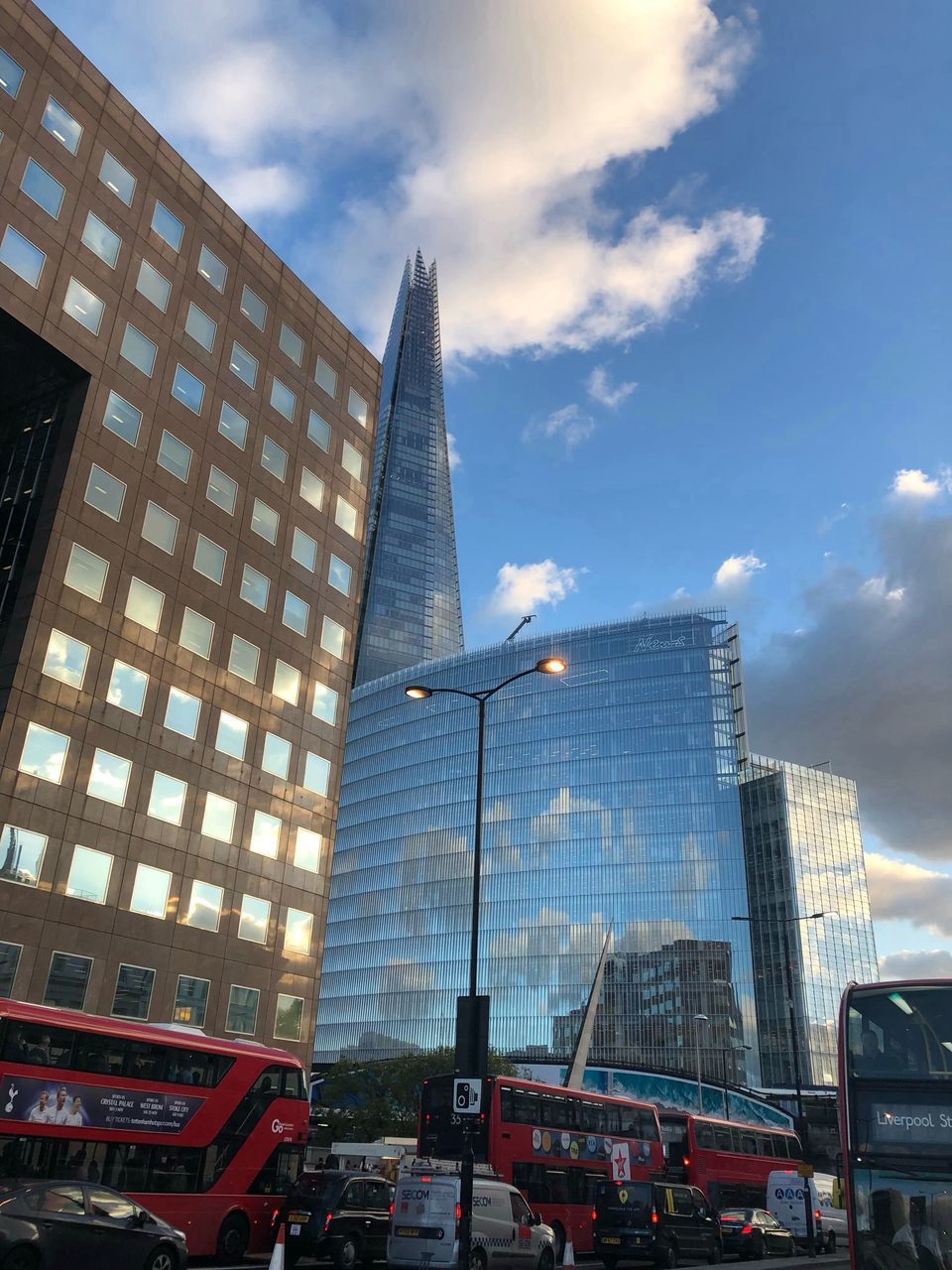 LOW ANGLE VIEW OF OFFICE BUILDING AGAINST CLOUDY SKY