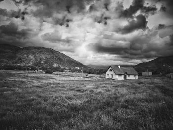Scenic view of grassy field against cloudy sky